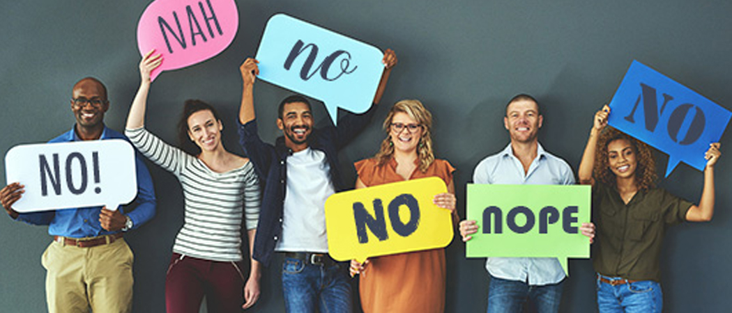 Professionals holding colourful “No” signs to promote healthy workplace boundaries
