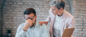 Two coworkers talking openly and supportively in a workplace setting.