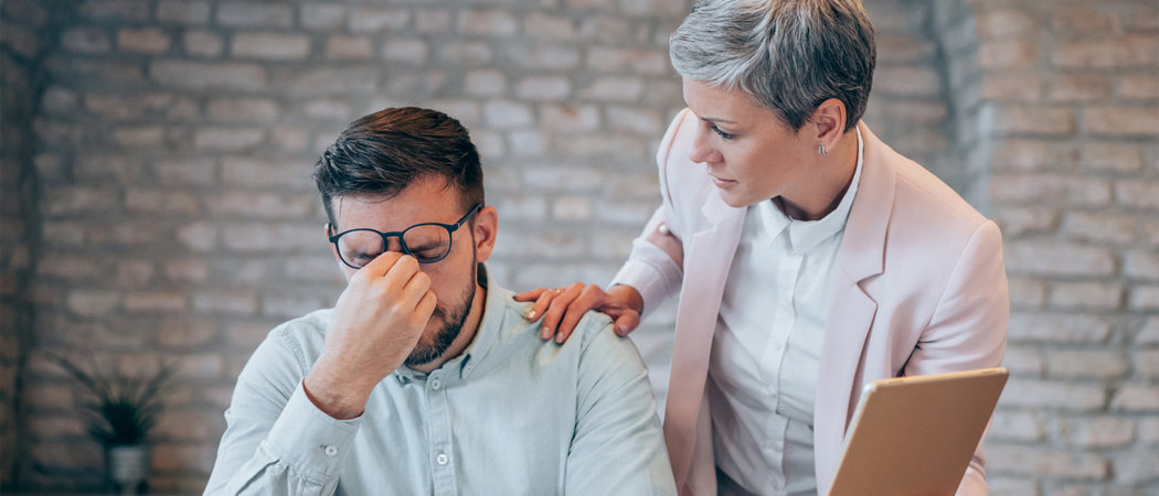 Two coworkers talking openly and supportively in a workplace setting.