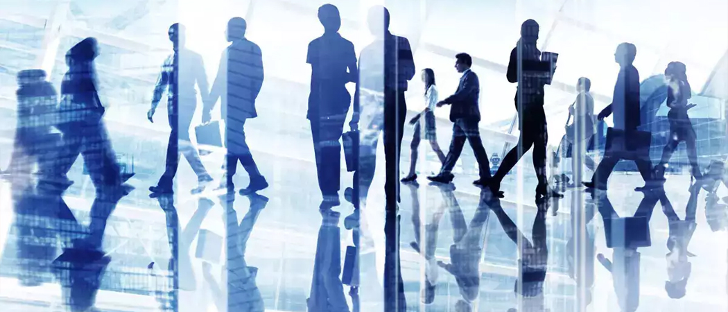 Business professionals walking through a modern office space, representing a motivated and active workplace culture.