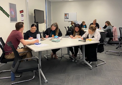 Carers Queensland staff members participating in an interactive Get Mentally Fit communication workshop around a conference table.