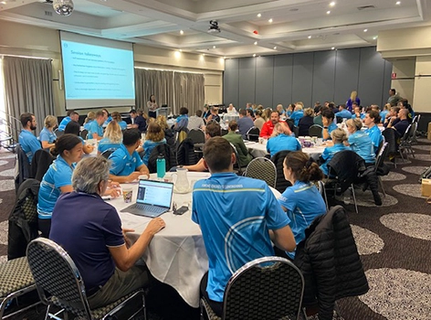 Get Mentally Fit presenter delivering a keynote training session to a large audience seated at round tables during the CVM Citypedia conference.