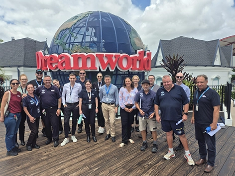 Dreamworld managers and Get Mentally Fit facilitators posing together for a group photo in front of the iconic Dreamworld globe.