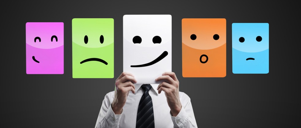 Professional holding up a discontent emoji face, surrounded by emoji icons expressing sadness and uncertainty.