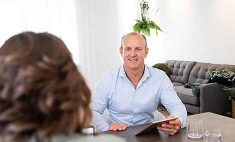 Scott Johnson, Co-Founder of Get Mentally Fit, holding a tablet during a workplace resilience consultation with a client.