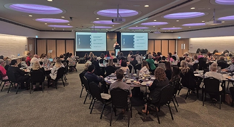 Get Mentally Fit facilitator delivering a psychological safety leadership workshop to the TAFE Queensland management team in a large auditorium setup.